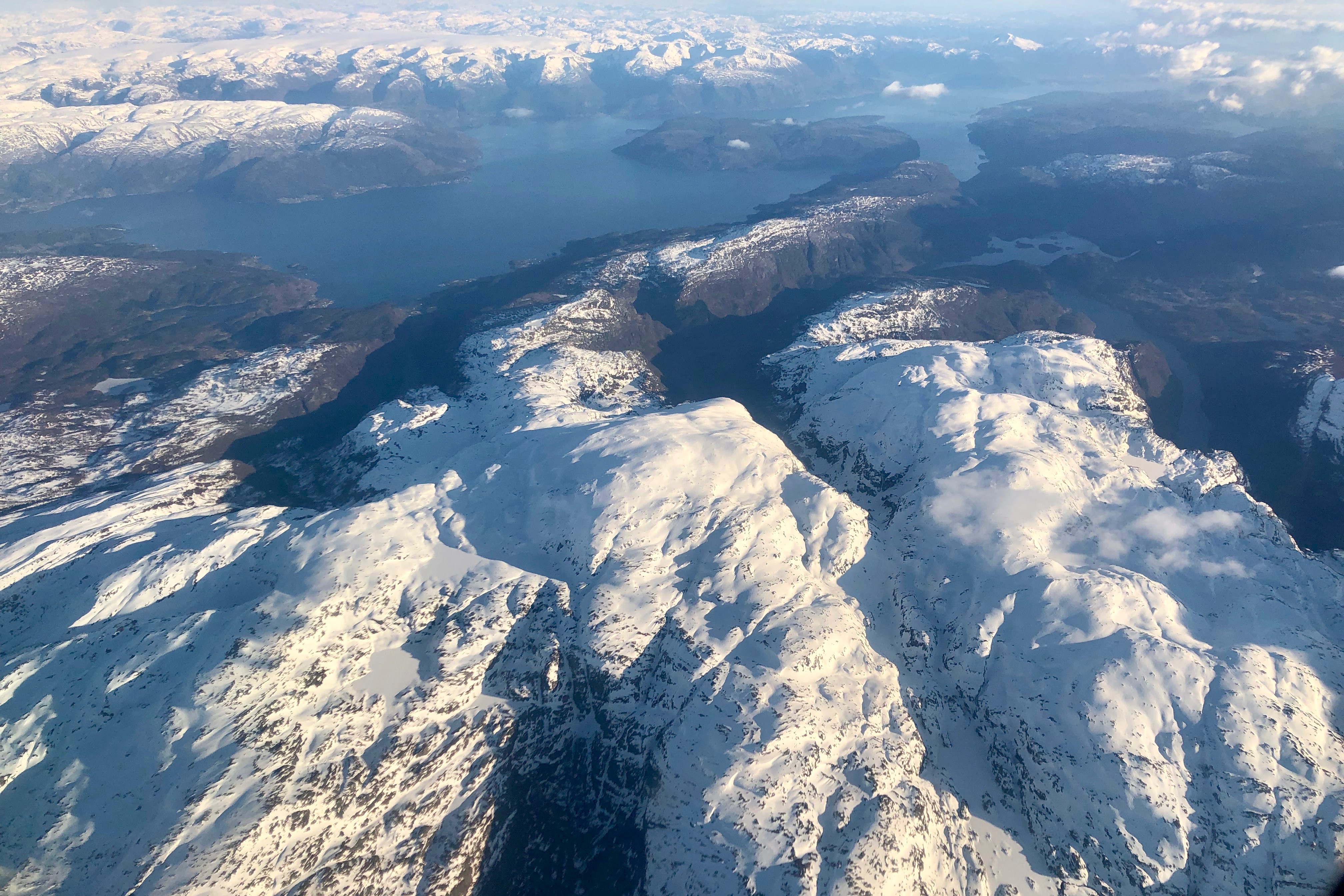 Tveitakvitingen (midt i bildet) sett fra luften med Hardangerfjorden, Rosendalsalpene og Folgefonna bak.
