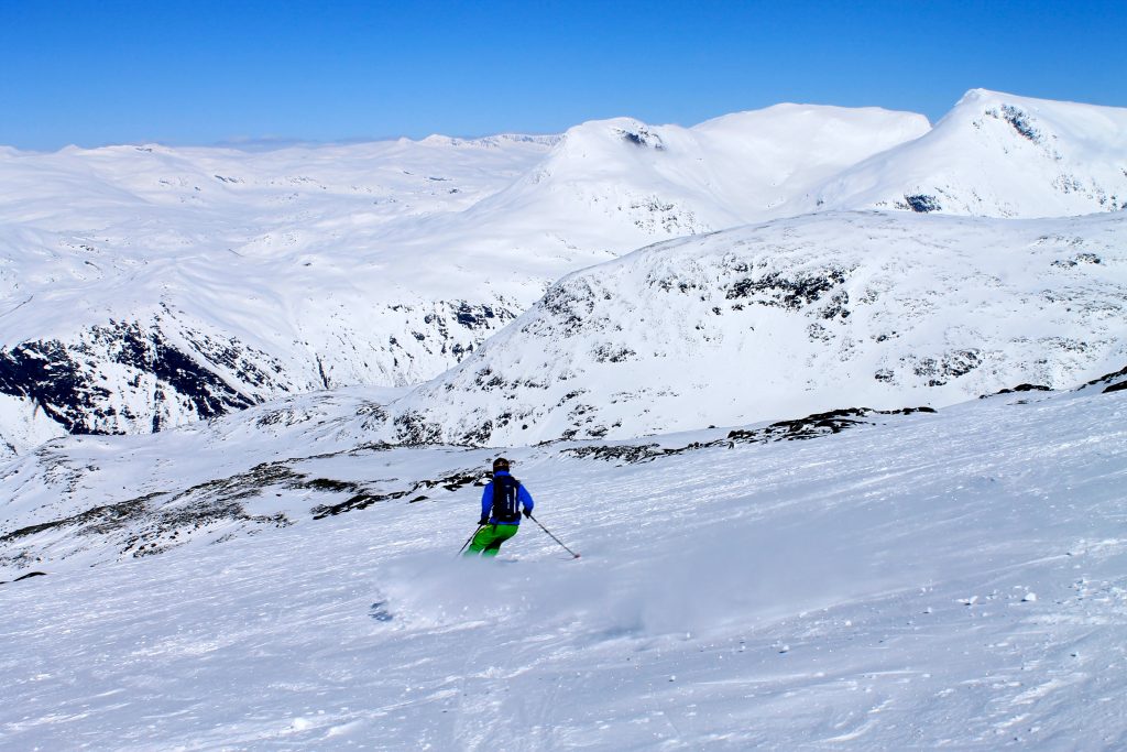 Skikjøring ned Dyrhaugsryggen med Steindalsnosi og Fannaråken i bakgrunnen.