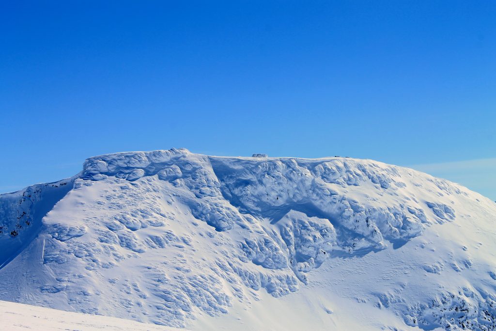 Fannaråkhytta er den høyestliggende turisthytten i Norge like ved toppen (2068 moh). Her er hytten dekket av snø og is.