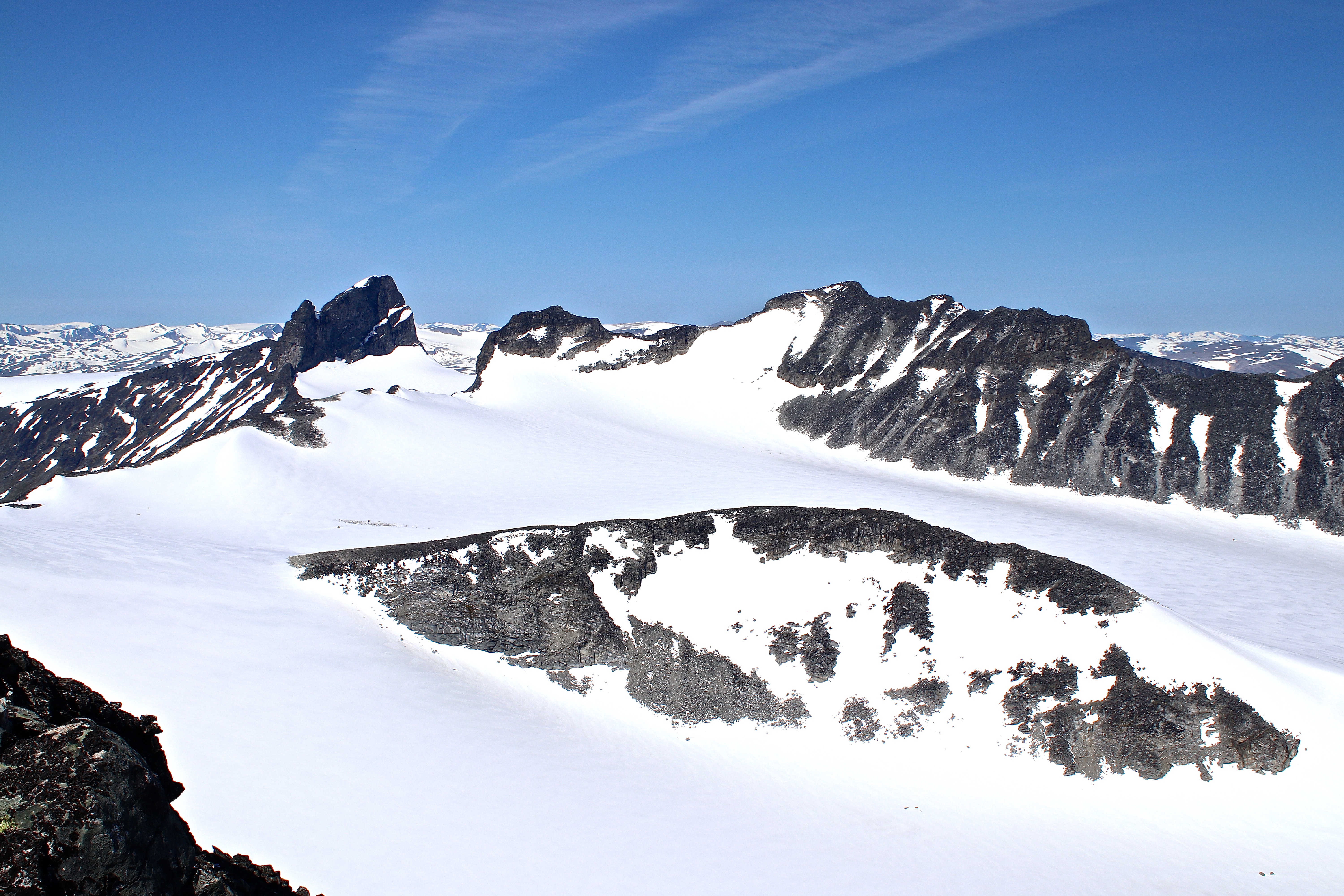Svellnosbrean sett fra Tverråtindan (3.002 moh). Svellnosbreahestan i midten, toppene Skardstinden, Ymmelstinden, Storjuvtinden og Galdhøpiggen bak.