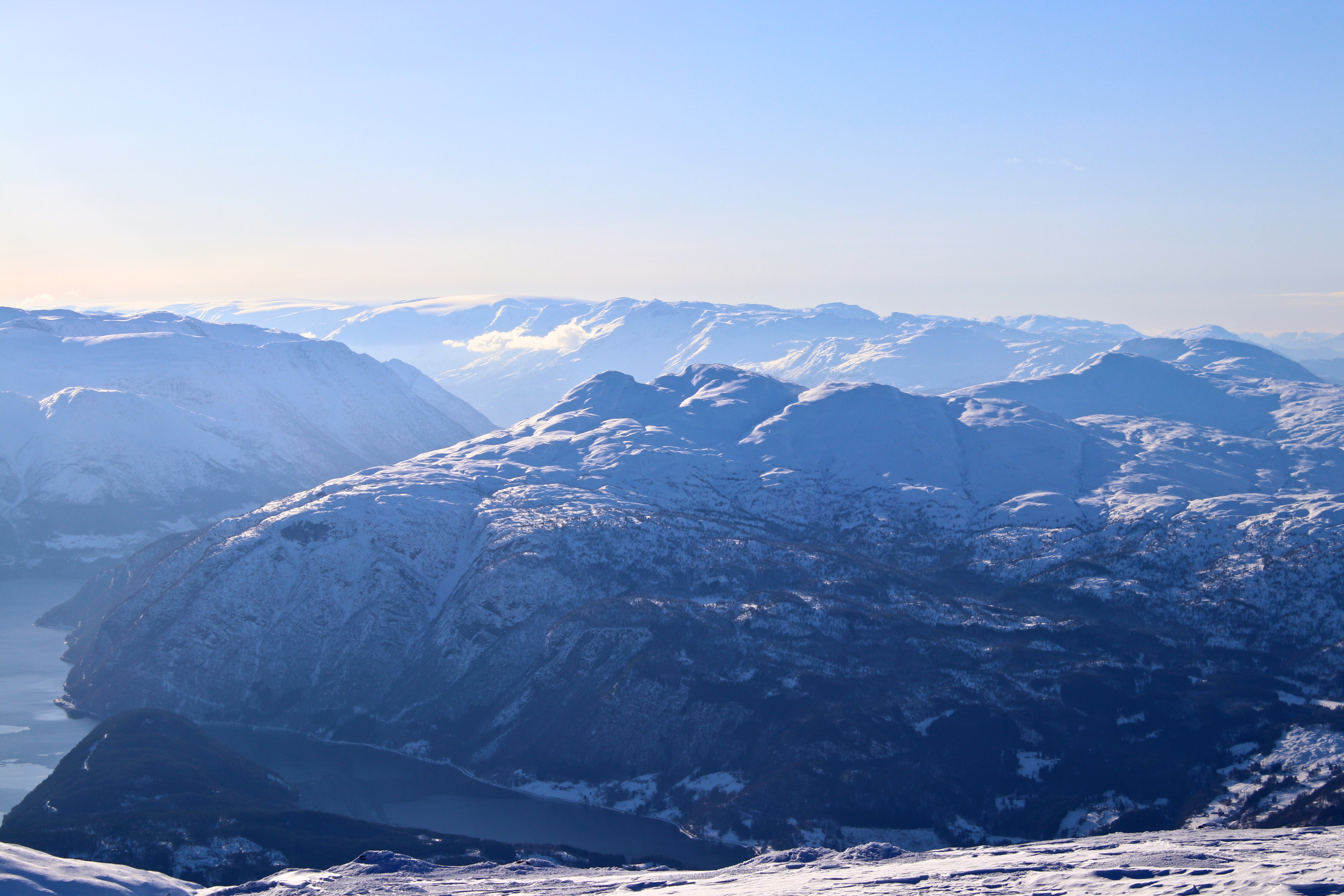 Skitoppene Midtfjell, Ingebjørgfjellet og Oksen med Folgefonna i bakgrunnen, her sett fra Vassfjøra.