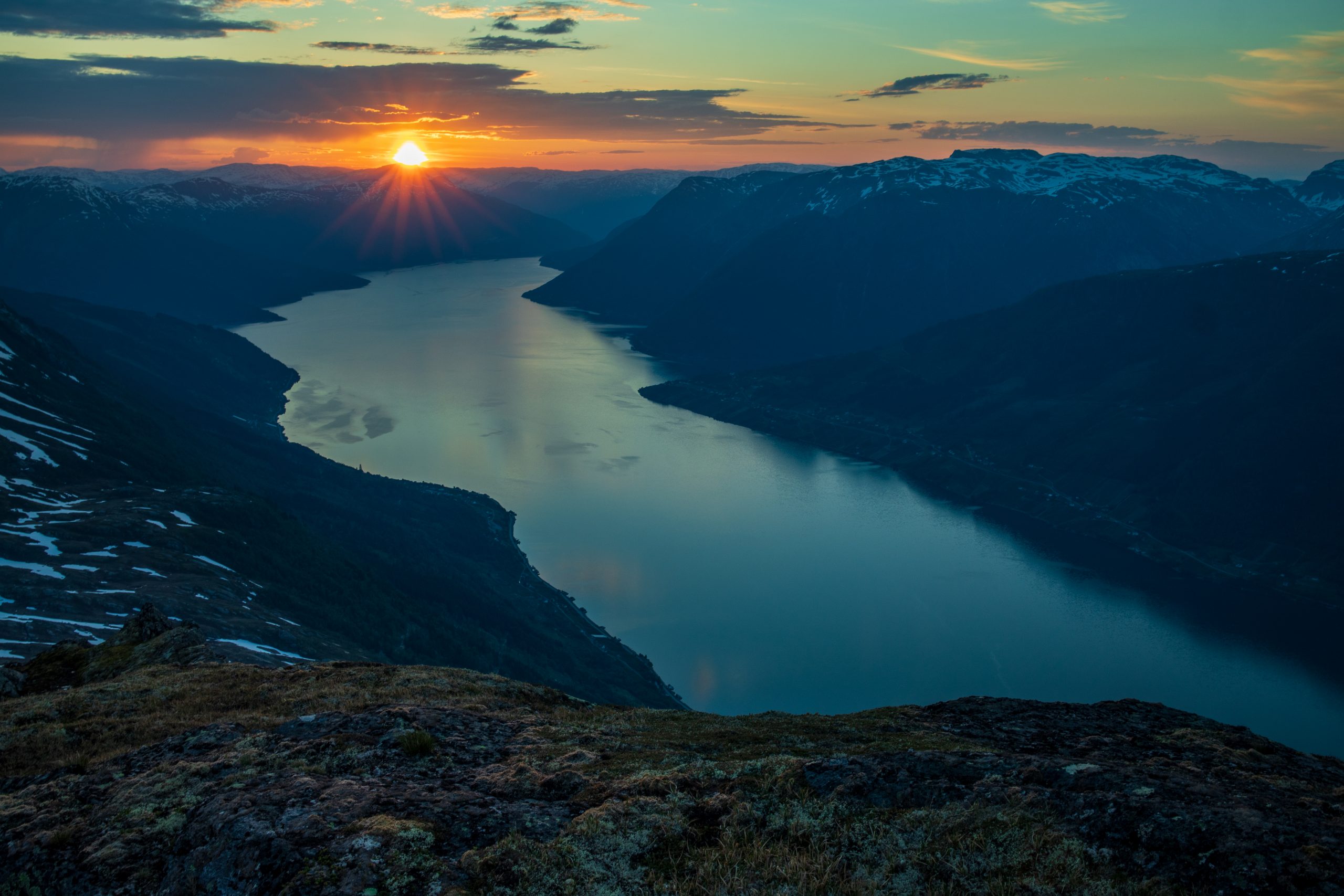 Solen står opp over Vassfjøro og Midfjellet. Utsikt fra Rundenuten.