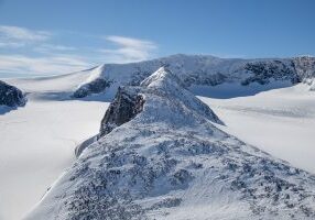 Trollsteineggje (2.300 moh) omgitt av Grotbrean og Glittertinden bak.