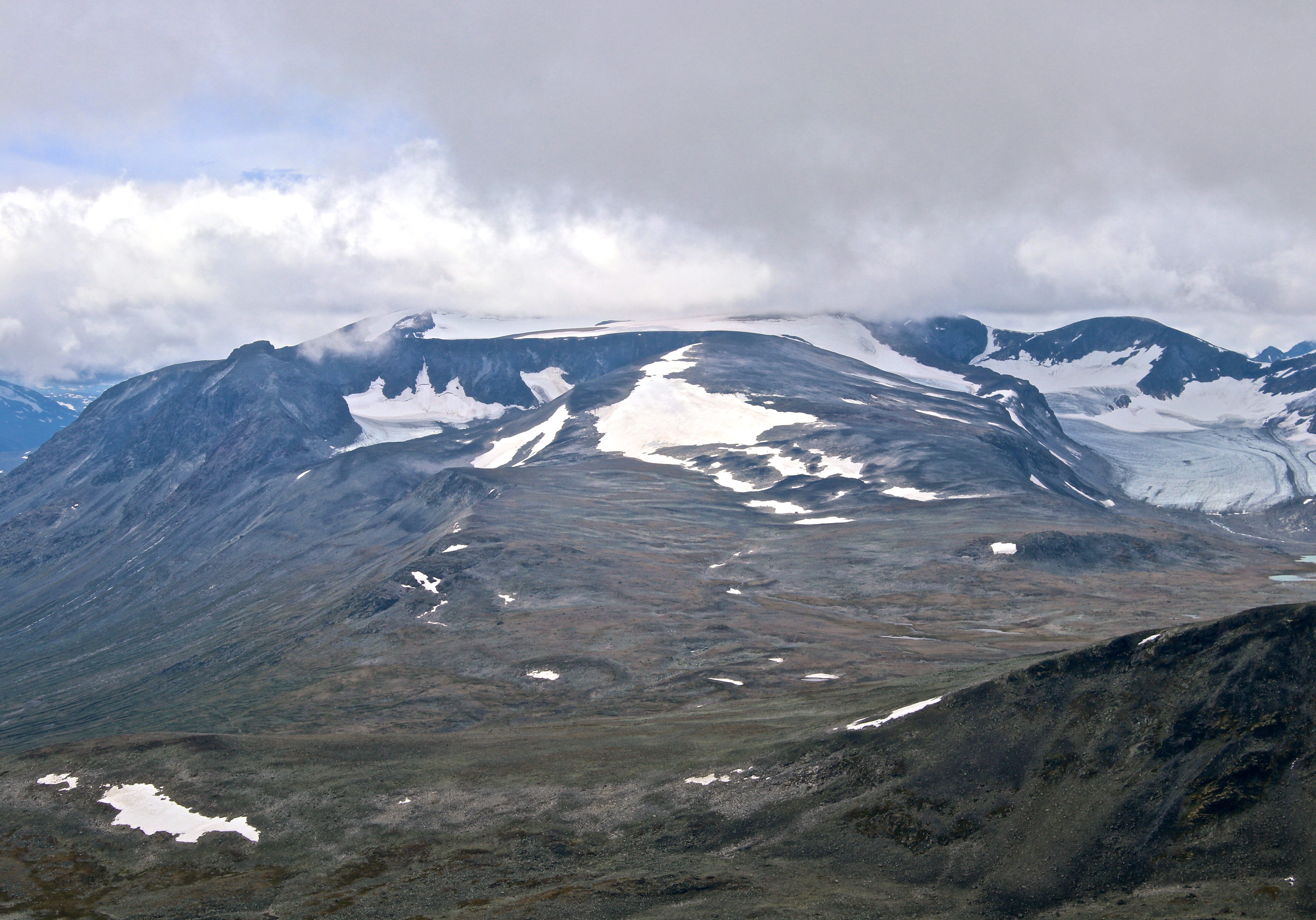 Surtningsuoksle (2.122 moh) sett fra nautgardstinden. Surtningssue gjemt i en sky like bak.